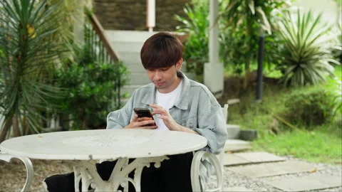 A cheerful moment captured as a man uses his phone with a joyful attitude. Video stock 249591903