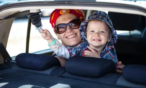 Cheerful mother and son at the back seat of a car Stock Photos