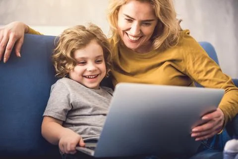 Cheerful mother enjoying exploiting computer with son Stock Photos