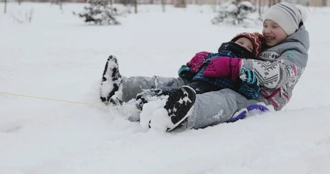 Cheerful mother pulling a sled with her ecstatic kids. Stock Footage 86090361