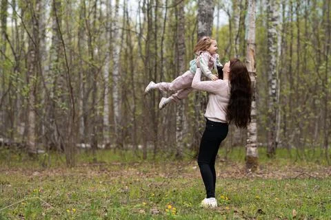 Cheerful mother rotating twisting making circle with her little daughter Stock Photos