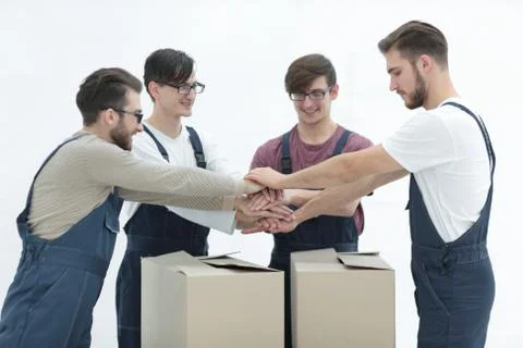 Cheerful movers leaning on stack of boxes isolated on white back 스톡 사진