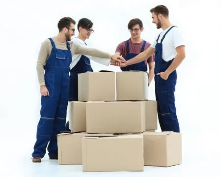 Cheerful movers leaning on stack of boxes isolated on white back 스톡 사진