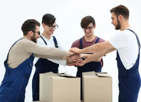 Cheerful movers leaning on stack of boxes isolated on white back 写真素材