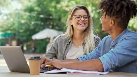 Cheerful multiethnic couple talking and enjoying while using laptop in cafe Stock Footage 109608087