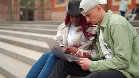 Cheerful multiethnic students using laptop on stairs Stock Footage 219887189