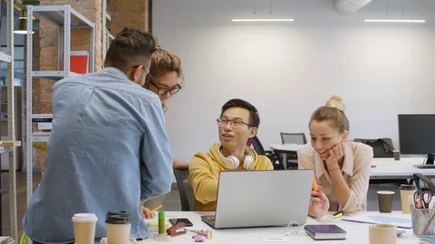 Cheerful Multiethnic Team Discussing Project on Laptop in Office Stock Footage 126136114