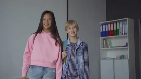 Cheerful multiracial classmates standing in classroom and looking at camera Video stock 142505867