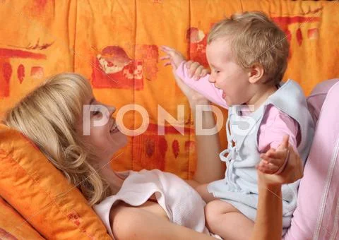 Cheerful mum plays with a daughter Stock Photos