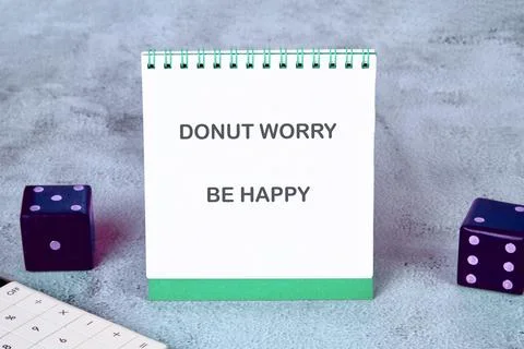 A cheerful notepad displaying the uplifting phrase Donut Worry Be Happy sit.. Stock Photos