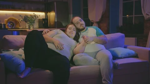 cheerful-obese-couple-relaxing-couch-footage-125050774_iconl.jpeg