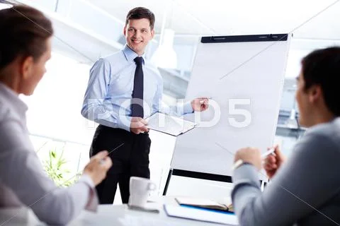 Cheerful office worker pointing at the blank whiteboard making a presentation Stock-Fotos