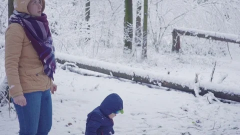 Cheerful one year boy and mother in the winter forest. 스톡 동영상 83364358