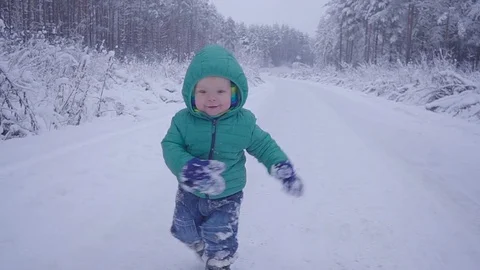 Cheerful one year boy in the winter forest road. created with gimbal 스톡 동영상 83342334
