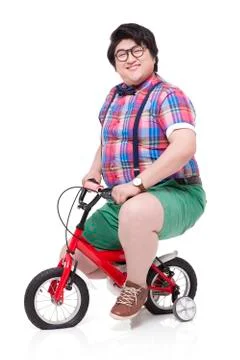 Cheerful overweight man riding an undersized bike 写真素材