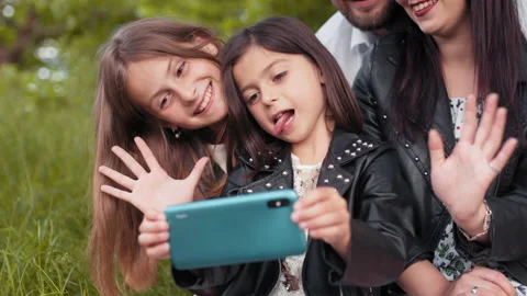 Cheerful parents with kids using mobile for taking selfie Stock Footage 157606000