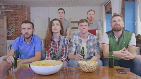 Cheerful people having fun while relaxing and watching tv in living room Stock Footage 124845564