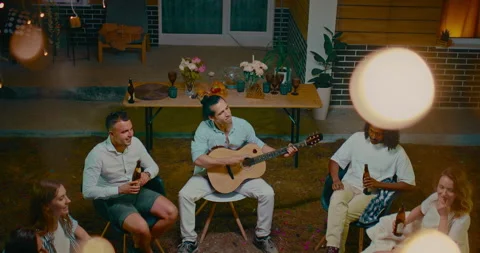 Cheerful people spending time in backyard, singing songs by guitar and drinking Stock Footage 258513679