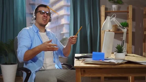A cheerful positive man an office worker or a freelancer plays imaginary drums Stock Footage 150863300
