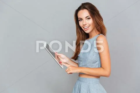 Cheerful pretty young woman using tablet computer Stock Photos