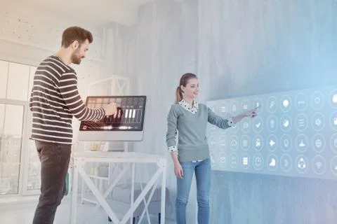Cheerful programmer working on computer while his coworker standing near Stock-Fotos