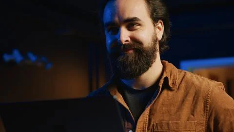 Cheerful programmer writing lines of code on notebook in living room Stockfoto's