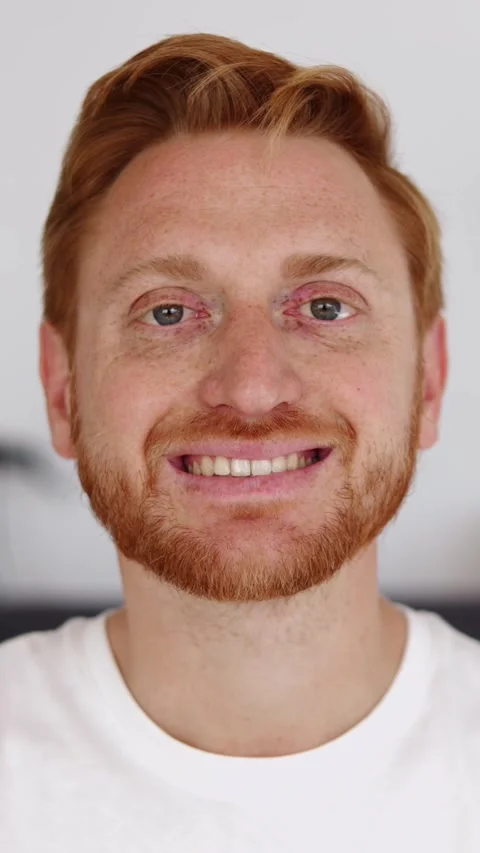 Cheerful red haired young man smiling at camera on video call from home Stock Footage 312200270