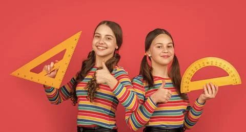 Cheerful school students hold math tool of triangle and protractor Stock Photos