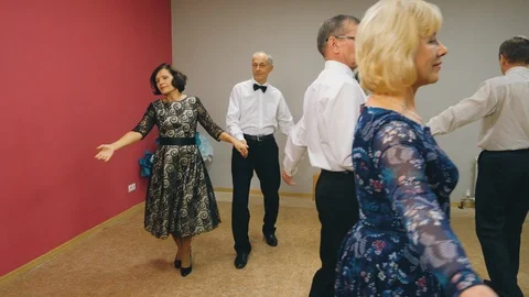 Cheerful senior couple dancing waltz in dance club. Mature man and woman Stock Footage