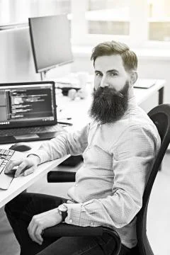 Cheerful senior programmer developer working in IT office, sitting at desk and 스톡 사진