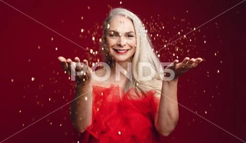 Cheerful senior woman throwing sparkles Stock Photos