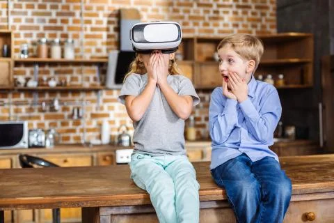 Cheerful siblings testing VR device Stock Photos