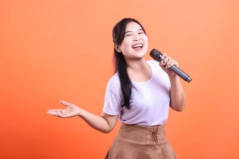 Cheerful Singer on Orange Background Stock Photos