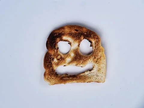 A cheerful slice of toasted bread with a smiling face Stock Photos