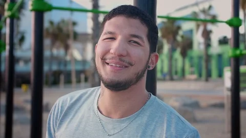 Cheerful smiling man standing and breathing heavily after workout at beach Stock Footage 108442863
