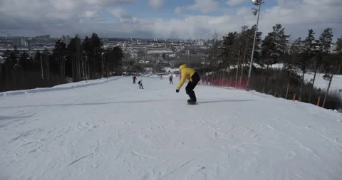 A cheerful snowboarder performs driving stunts on the board Stock Footage 150364714