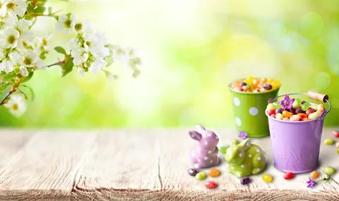 A cheerful spring setup featuring candy-filled pastel buckets, ceramic bunn.. Stock Photos