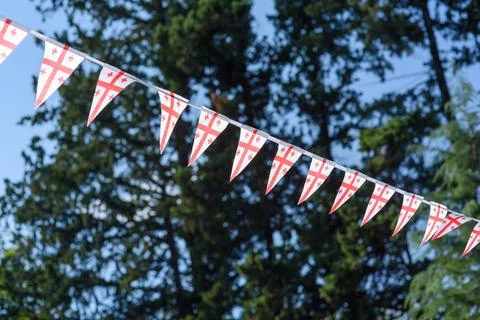 A cheerful string of triangular flags of Georgia featuring a red cross on a.. Stock Photos