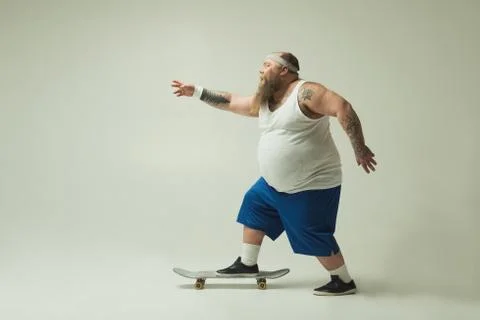 Cheerful thick guy chasing on skate Stock Photos