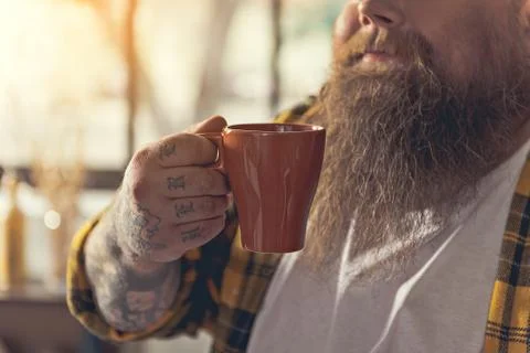 Cheerful thick guy drinking hot beverage Stock Photos