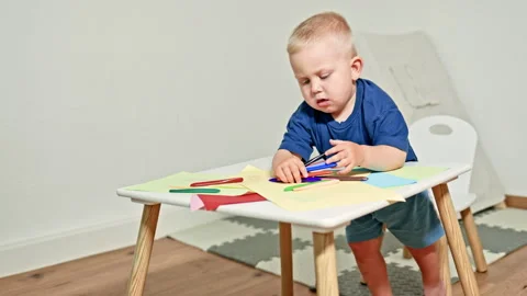 Cheerful toddler learns to draw with colored pencils. Child develops and learns 스톡 동영상 319907762