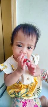 Cheerful Toddler Smiling Brightly While Eating Lychee Fruit at Home Stock Photos