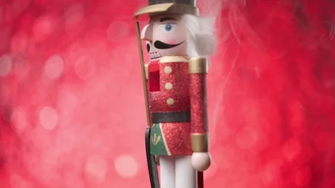 Cheerful Toy Nutcracker spins against vibrant red bokeh lights and smoke, ending Stock Footage 321679244