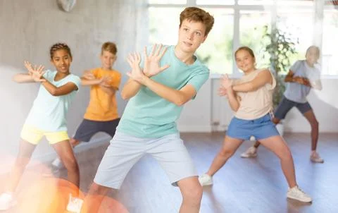 Cheerful tween boy practicing energetic dance in choreography class Stock Photos