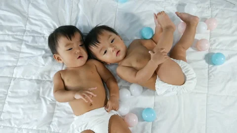Cheerful twin babies on a bed Stock Footage 135518697