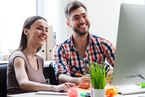 Cheerful two colleagues are using laptop for work Foto stock