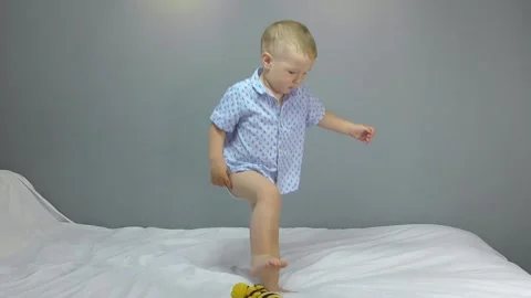 Cheerful two year old kid dancing on a gray background Stock Footage 139181408