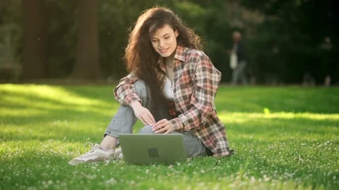 Cheerful woman is communicating on the internet using her laptop while sitting Stock Footage 197571707