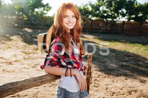 Cheerful woman cowgirl standing in village Stock Photos