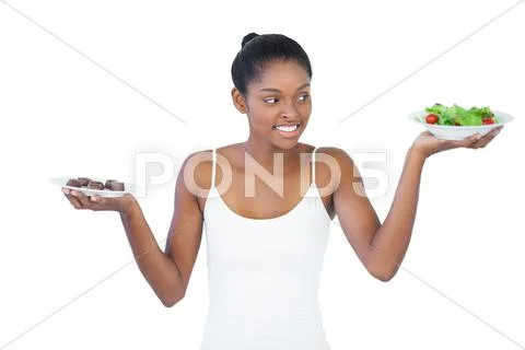 Cheerful woman deciding to eat healthily or not Stock Photos